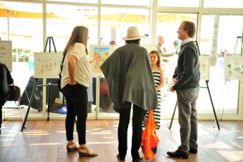Attendees chat while viewing the winning posters
